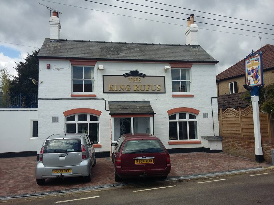 The King Rufus, a white painted village pub with a slate roof, two chimney stacks and a block paved forecourt